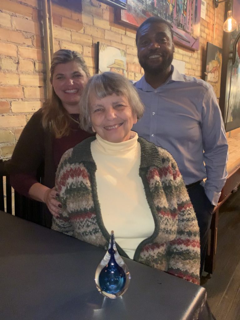 Donor Betty Shaw with her daughter and son-in-law receiving a water droplet for her newly established endowed scholarship at Augsburg.